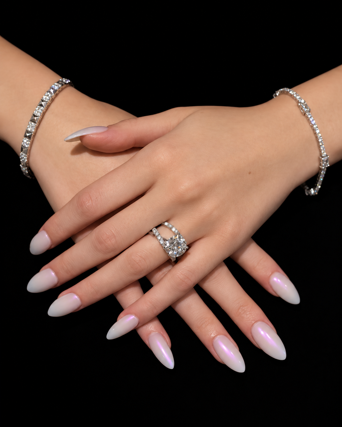 Diamond engagement ring and two diamond bracelets worn against black
