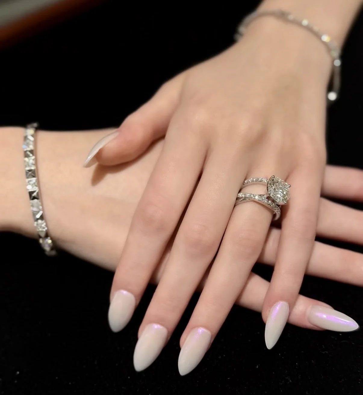 Diamond engagement ring and wedding band worn on a hand