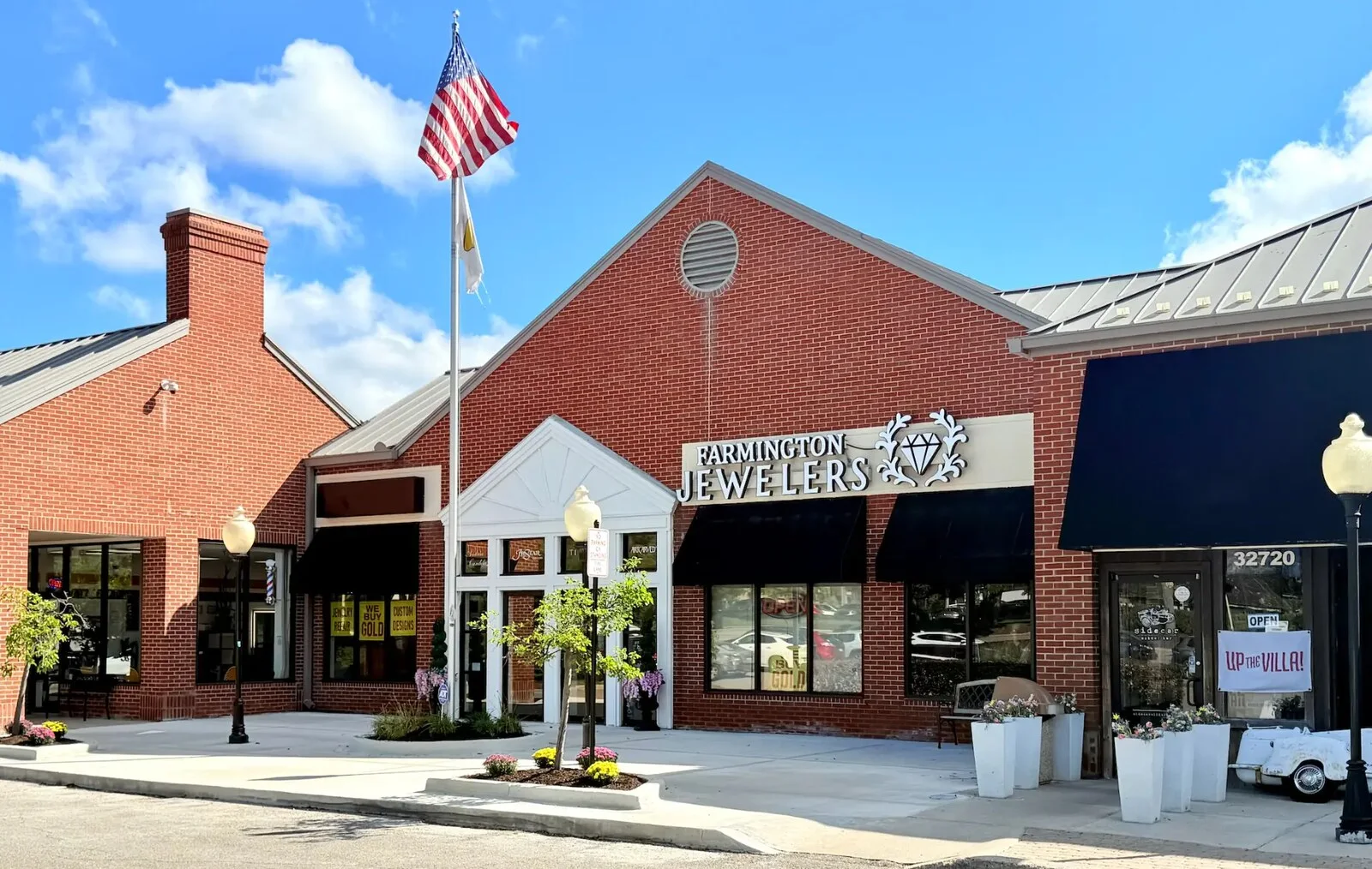 Red brick Farmington Jewelers storefront with diamond sign and black awnings on Grand River Avenue